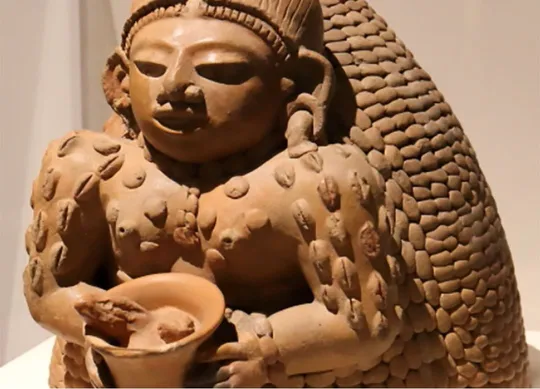 Figura femenina de barro con semillas de cacao